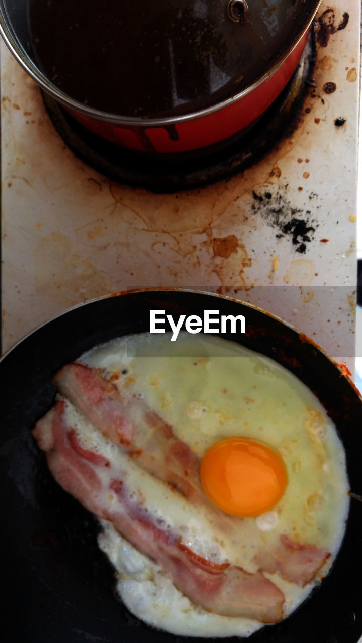 Directly above shot of eggs and bacons in pan on table