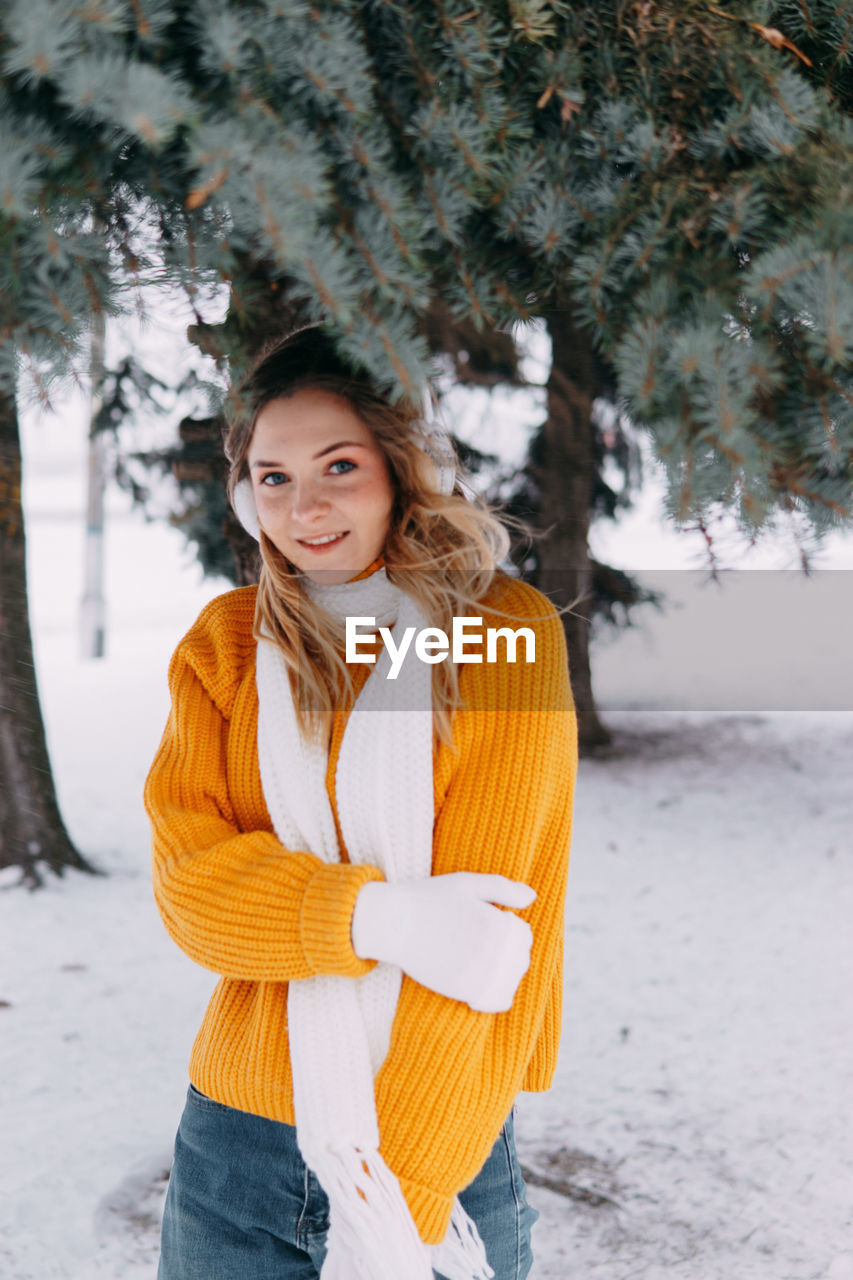 Teen blonde in a yellow sweater outside in winter. a teenage girl on a walk in winter clothes