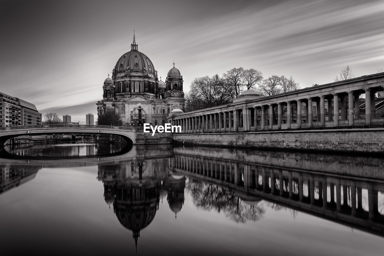 Reflection of church in river against sky