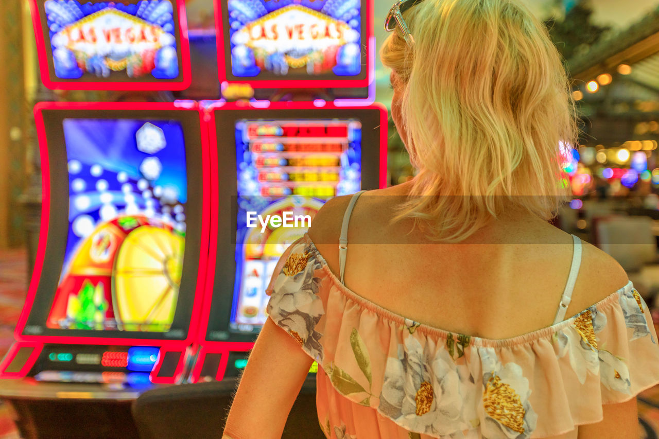 Rear view of woman standing in casino