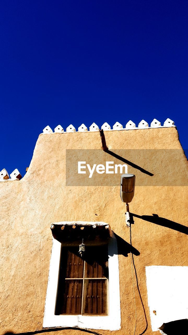 LOW ANGLE VIEW OF BUILDING AGAINST CLEAR BLUE SKY