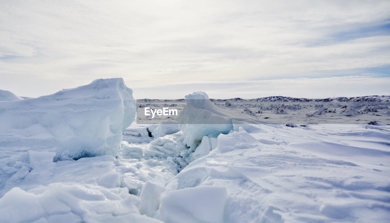 Snow covered landscape against sky