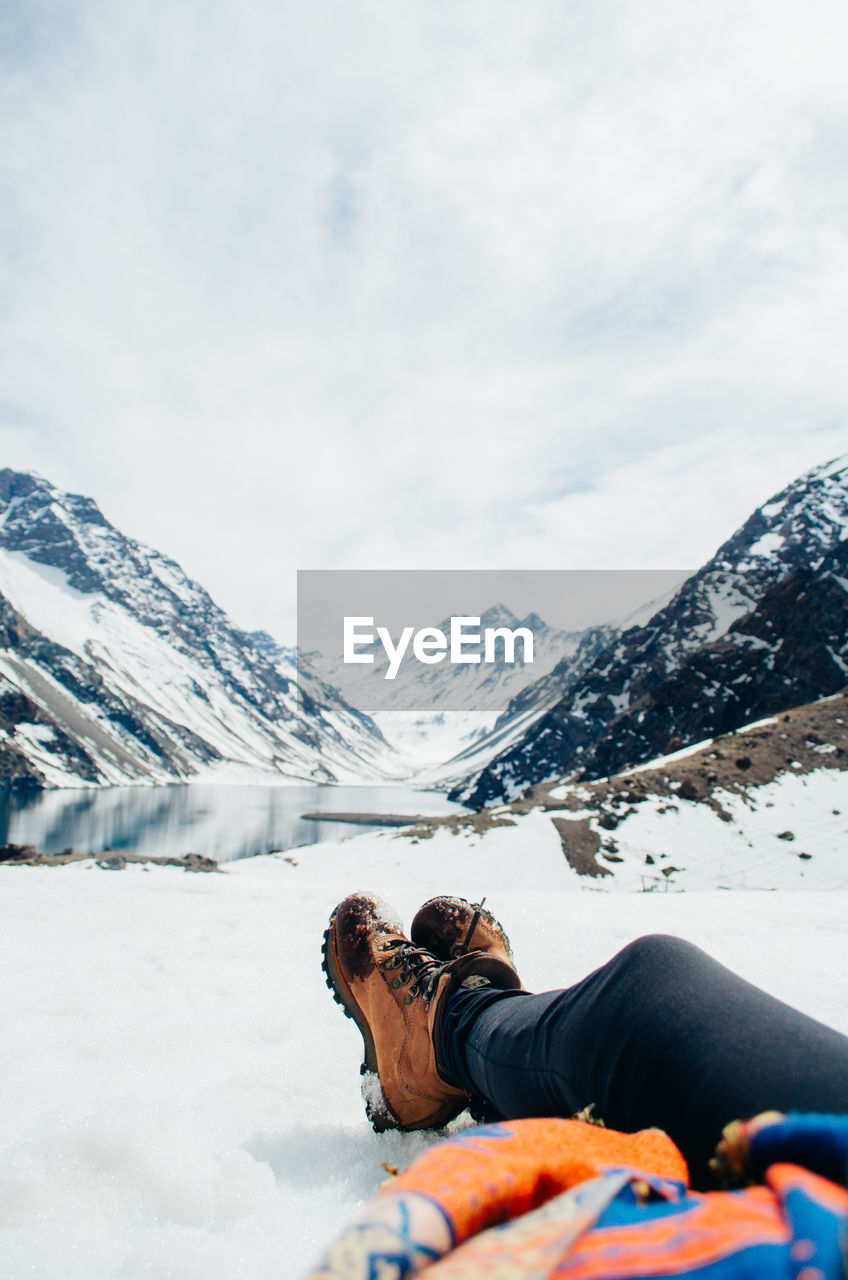 Low section of woman relaxing on snow covered land