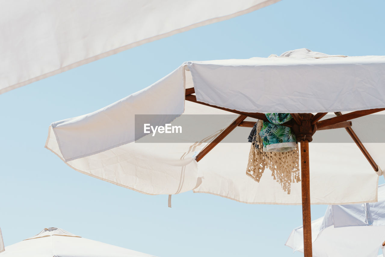 LOW ANGLE VIEW OF PARASOLS AGAINST SKY