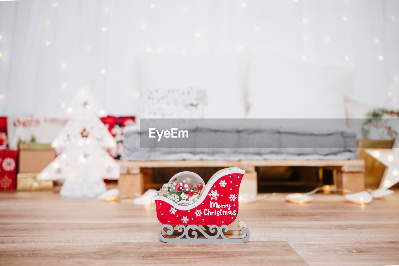 celebration, christmas, decoration, indoors, holiday, home interior, domestic room, no people, christmas decoration, furniture, gift, living room, flooring, event, hardwood floor, focus on foreground, red, table, tradition, nature, wood, emotion, christmas tree, tree, domestic life