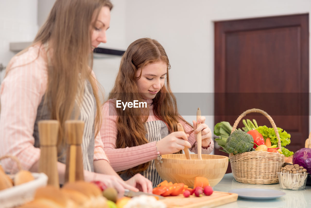 Mother and girl having food at home