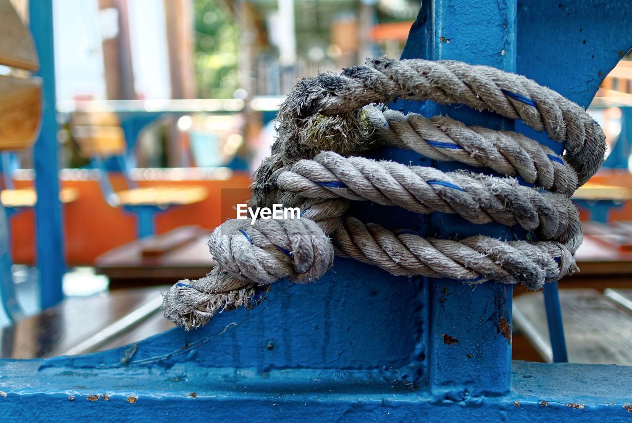 Close-up of rope tied on blue metal post