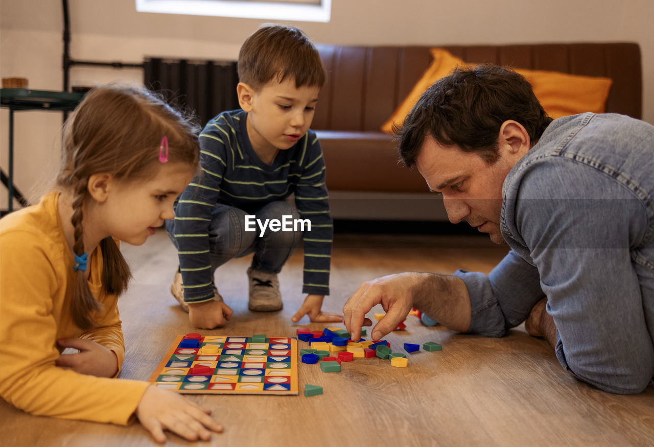 high angle view of mother playing with toy blocks