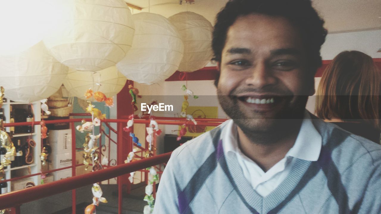 Smiling mid adult man standing by lanterns