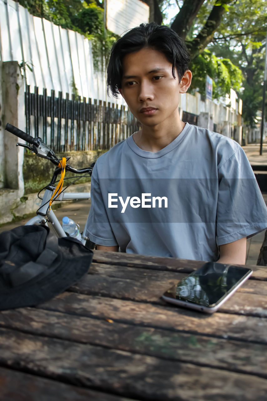 Portrait of young man sitting on table