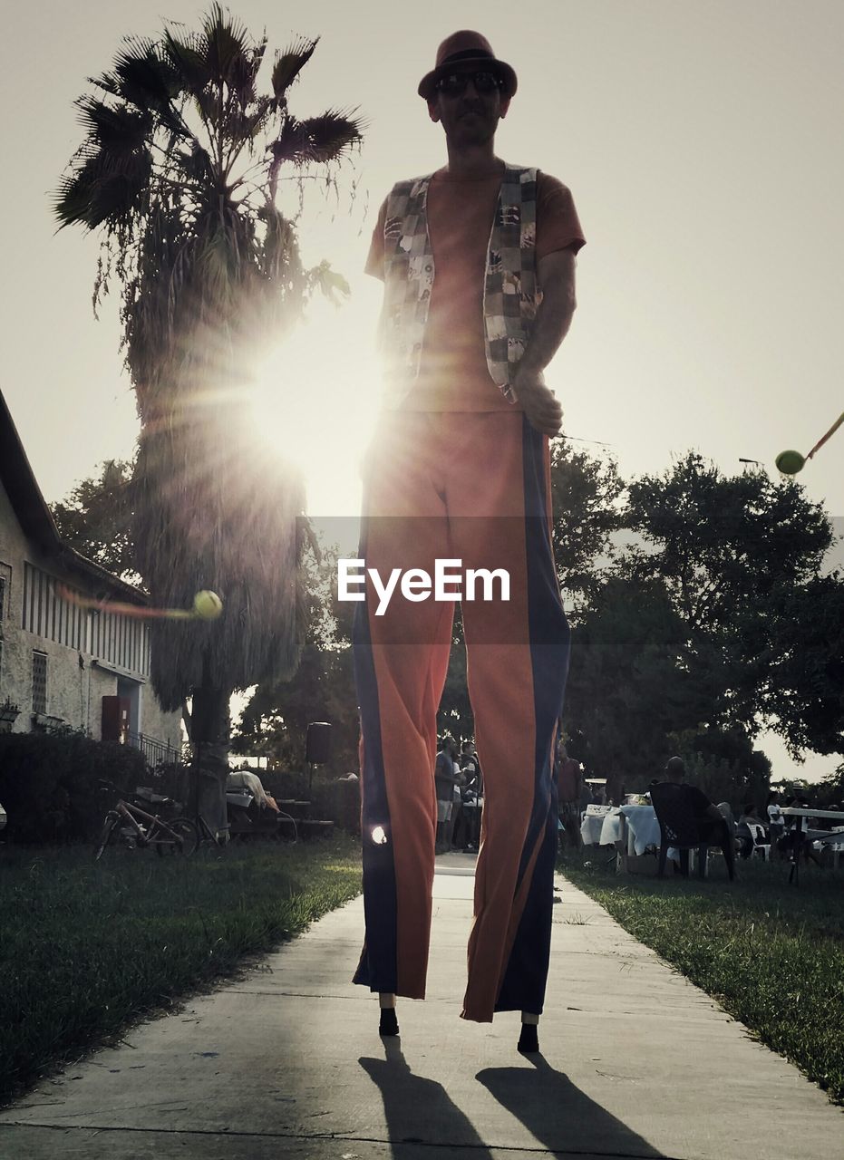 Man walking on stilts in park