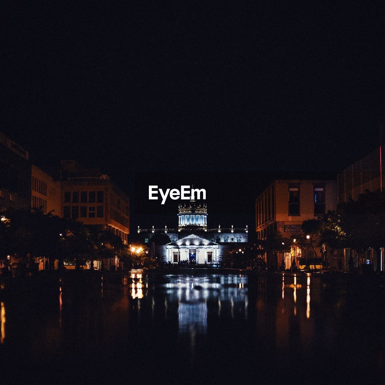 Illuminated buildings with reflection in water at night