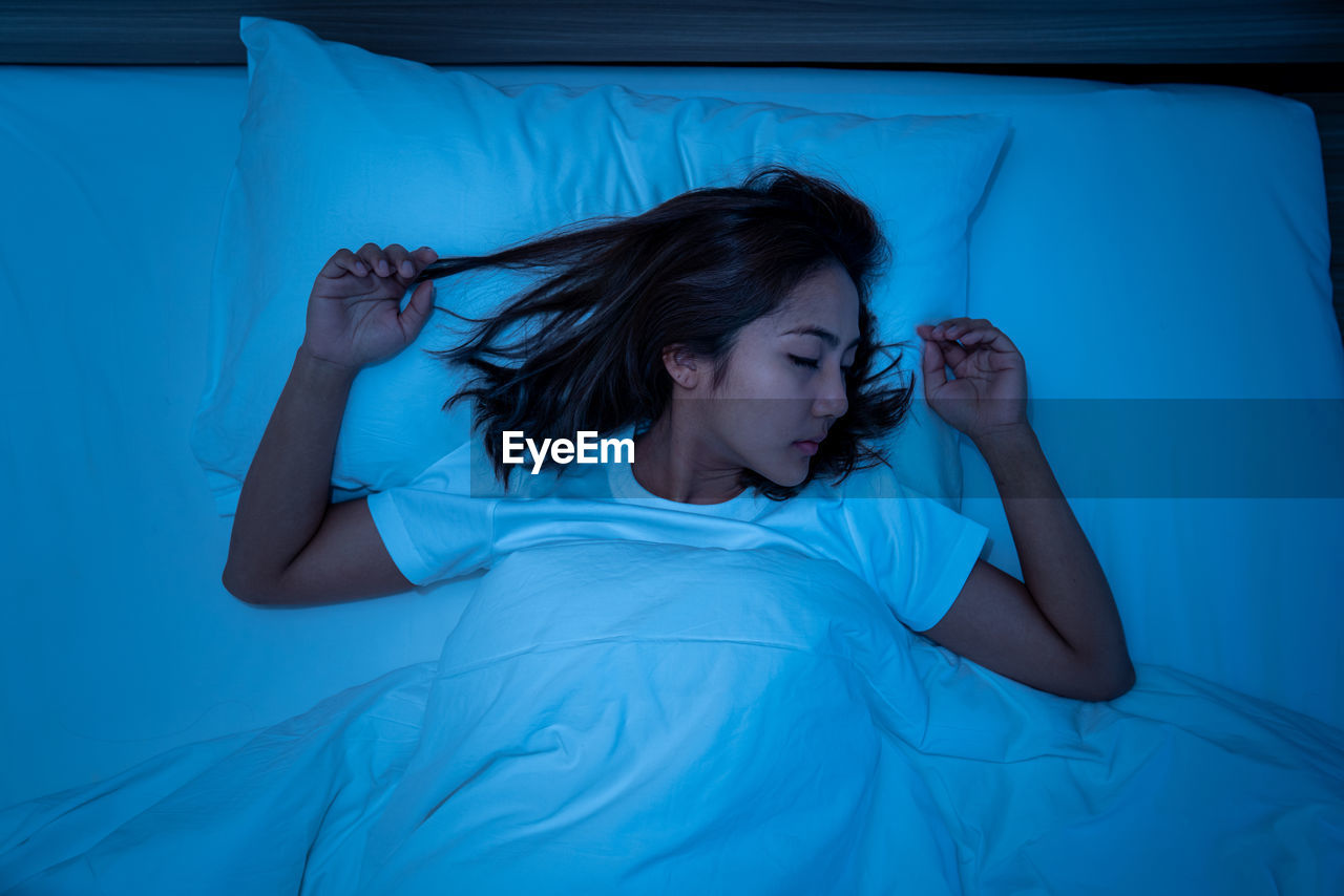 Young woman sleeping in bed