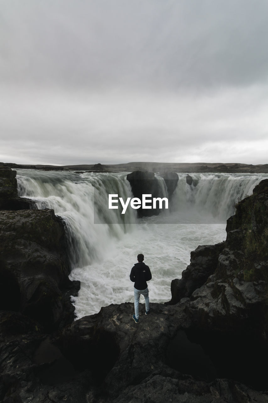 SCENIC VIEW OF WATERFALL WITH CLIFF AGAINST SKY