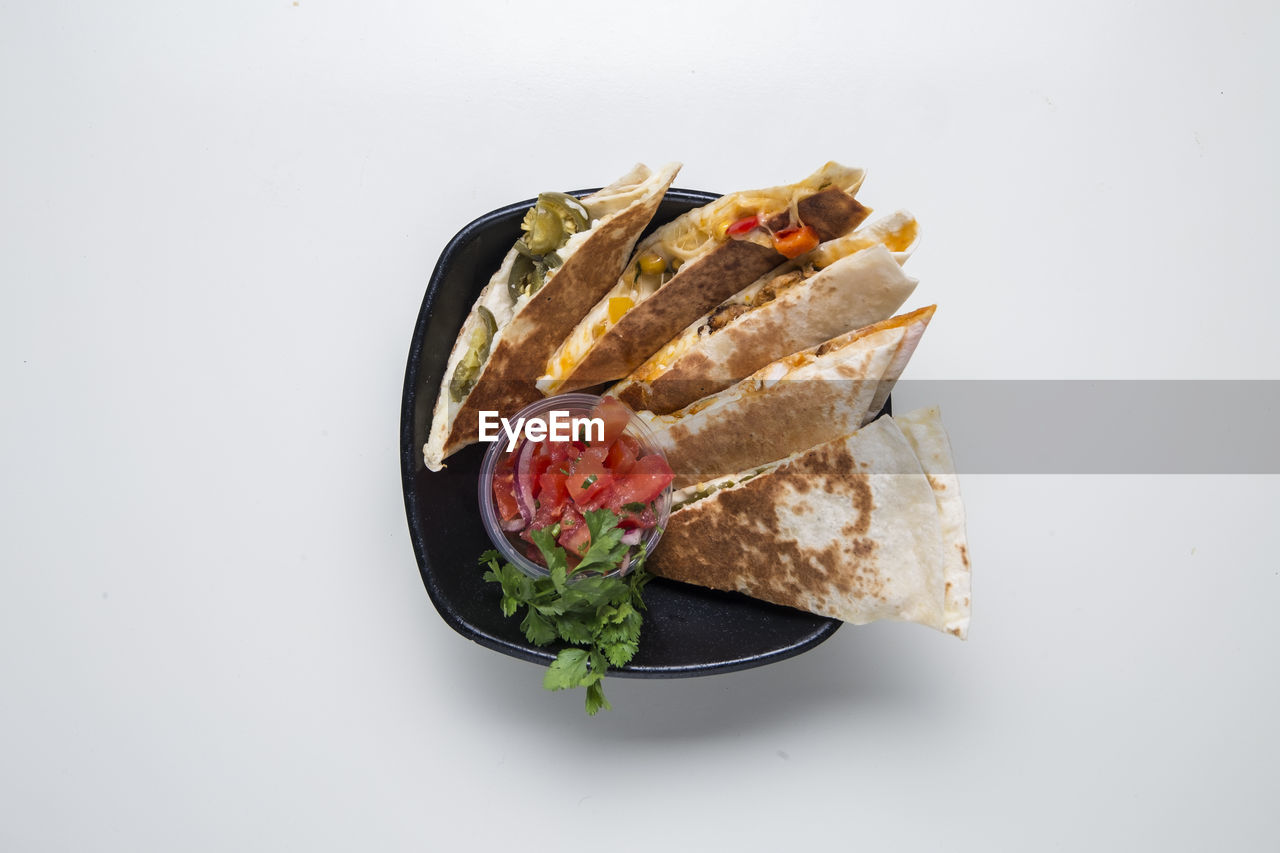 Directly above shot of food in plate against white background