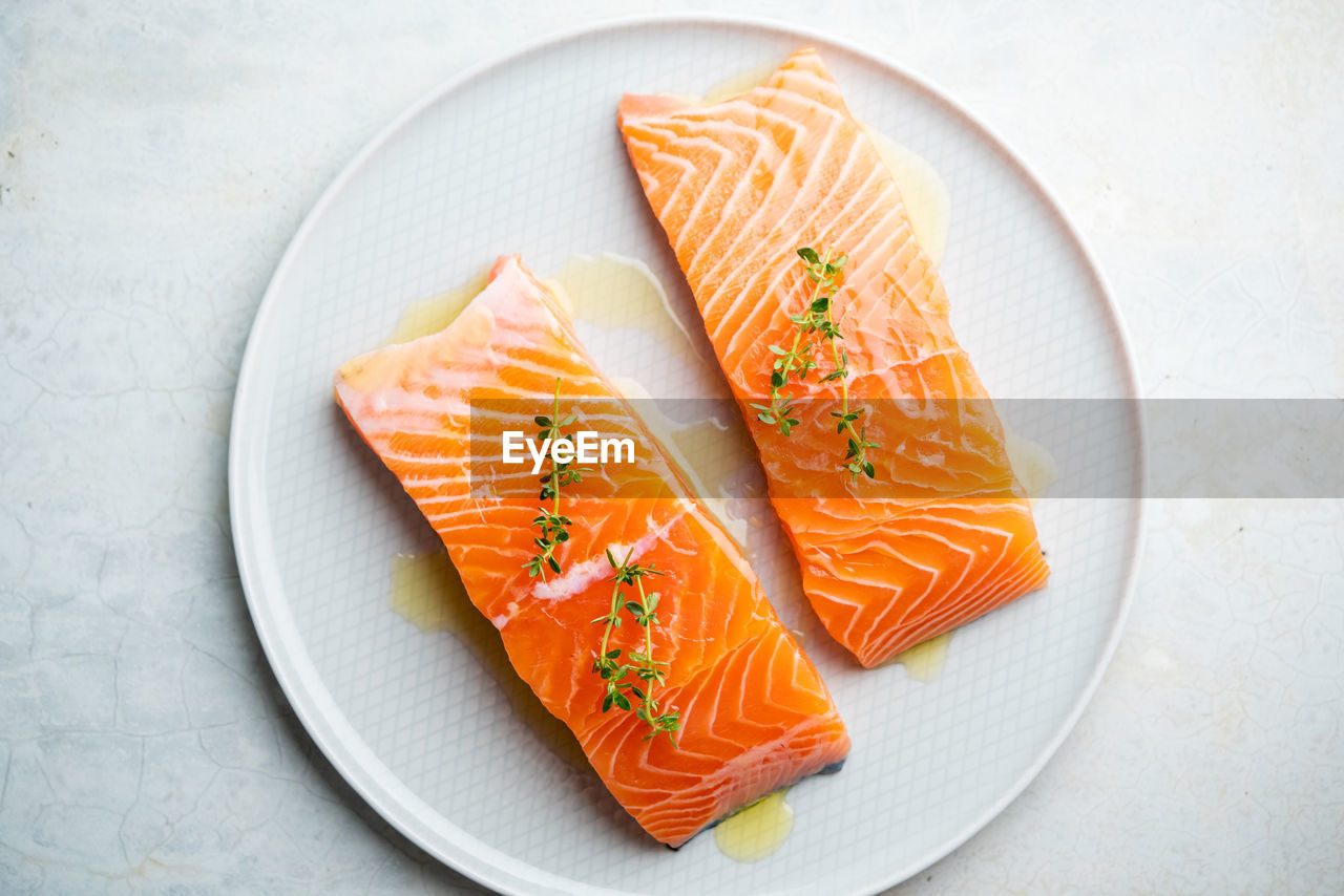 Fresh salmon fillet with herbs on a plate for delicious salmon steak.