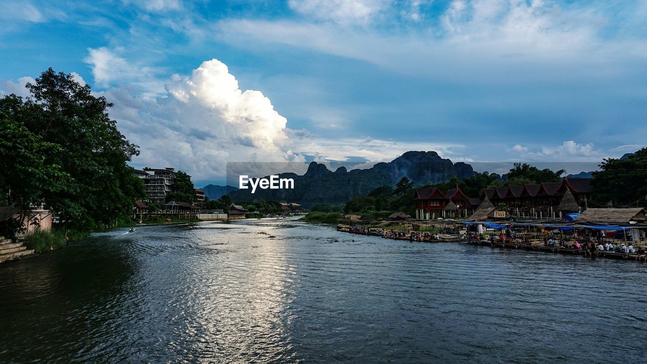 Scenic view of river by mountains against sky