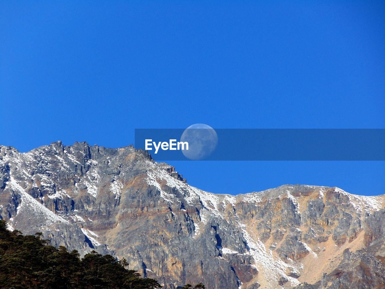 LOW ANGLE VIEW OF SNOWCAPPED MOUNTAIN AGAINST CLEAR BLUE SKY