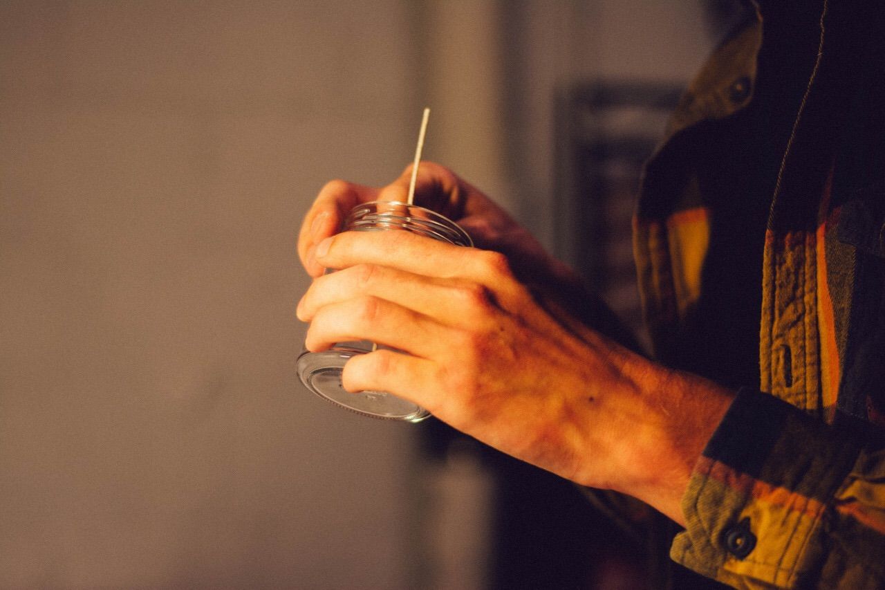 Midsection of person holding candle in jar