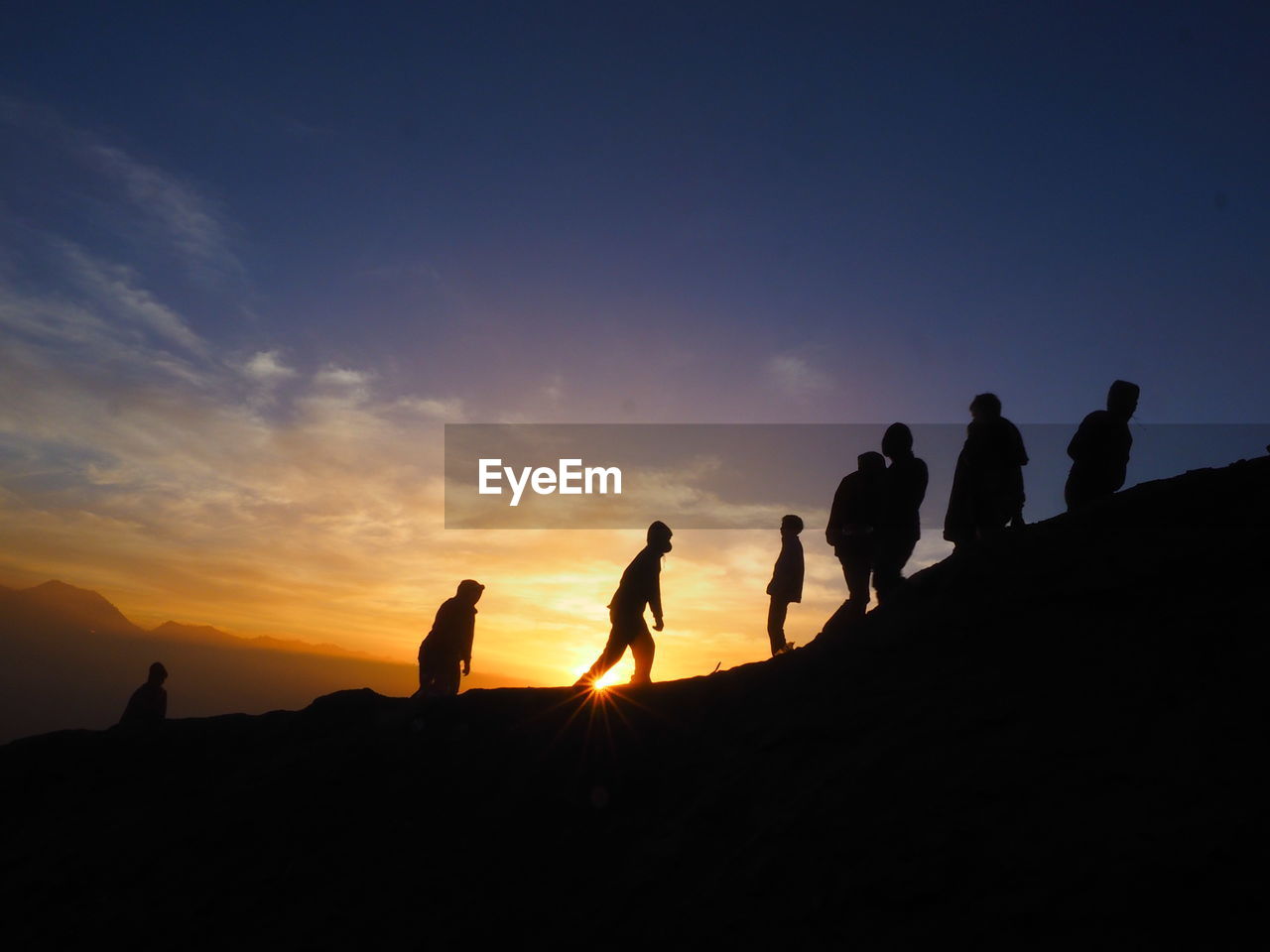 SILHOUETTE PEOPLE ON MOUNTAIN DURING SUNSET