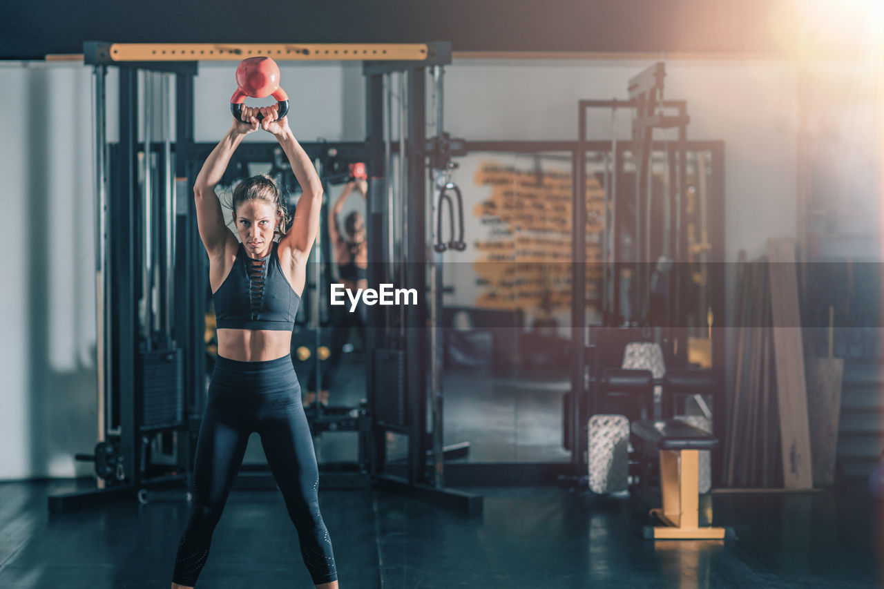 Woman swinging kettlebell in the gym.