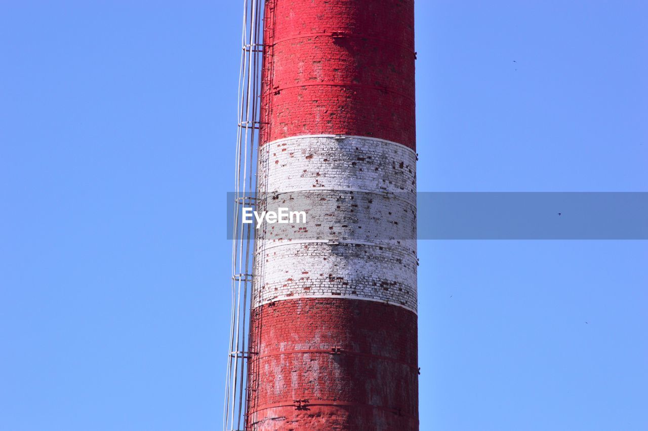 LOW ANGLE VIEW OF SMOKE STACKS AGAINST CLEAR SKY