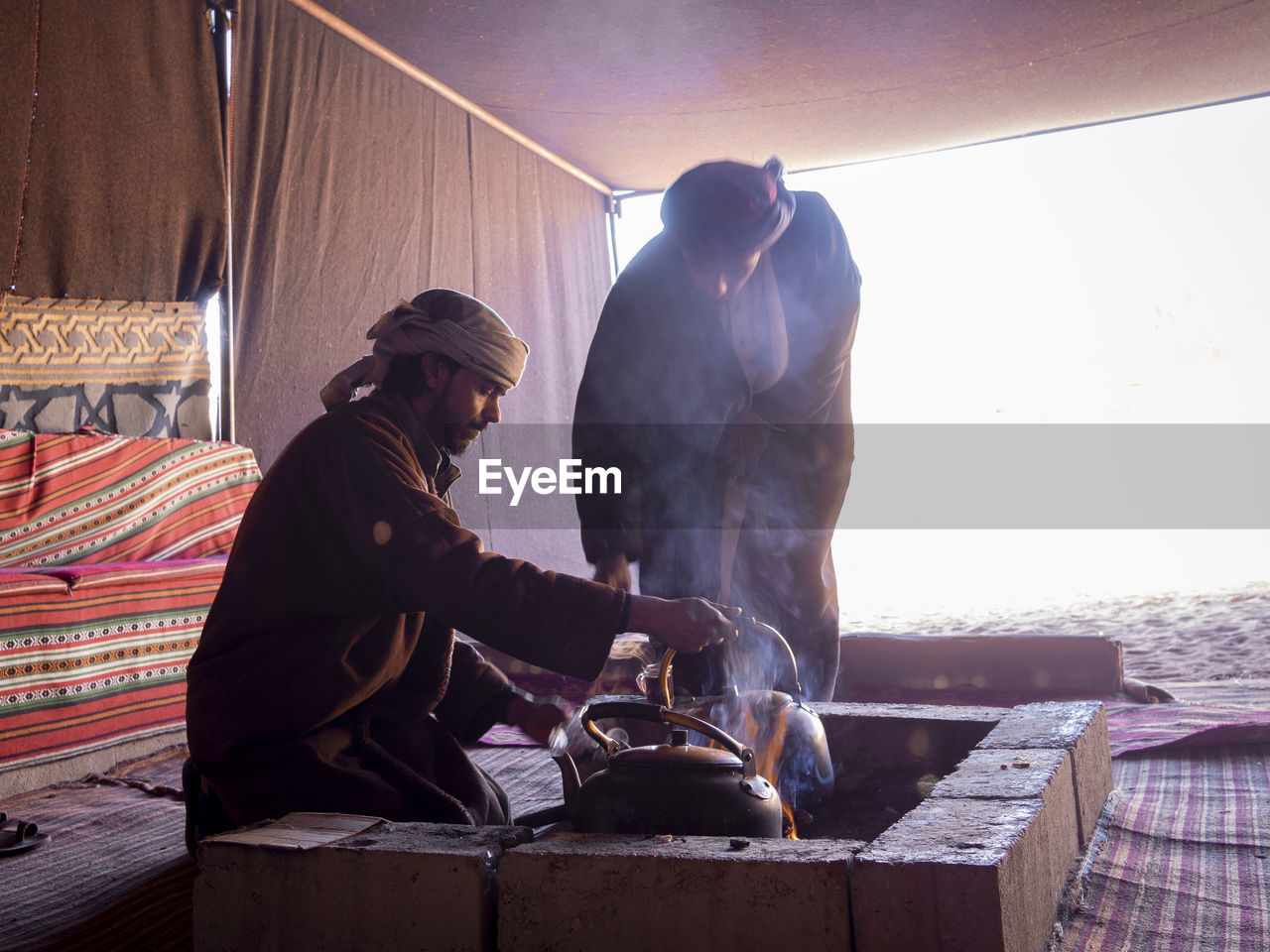 MAN WORKING ON GRILL