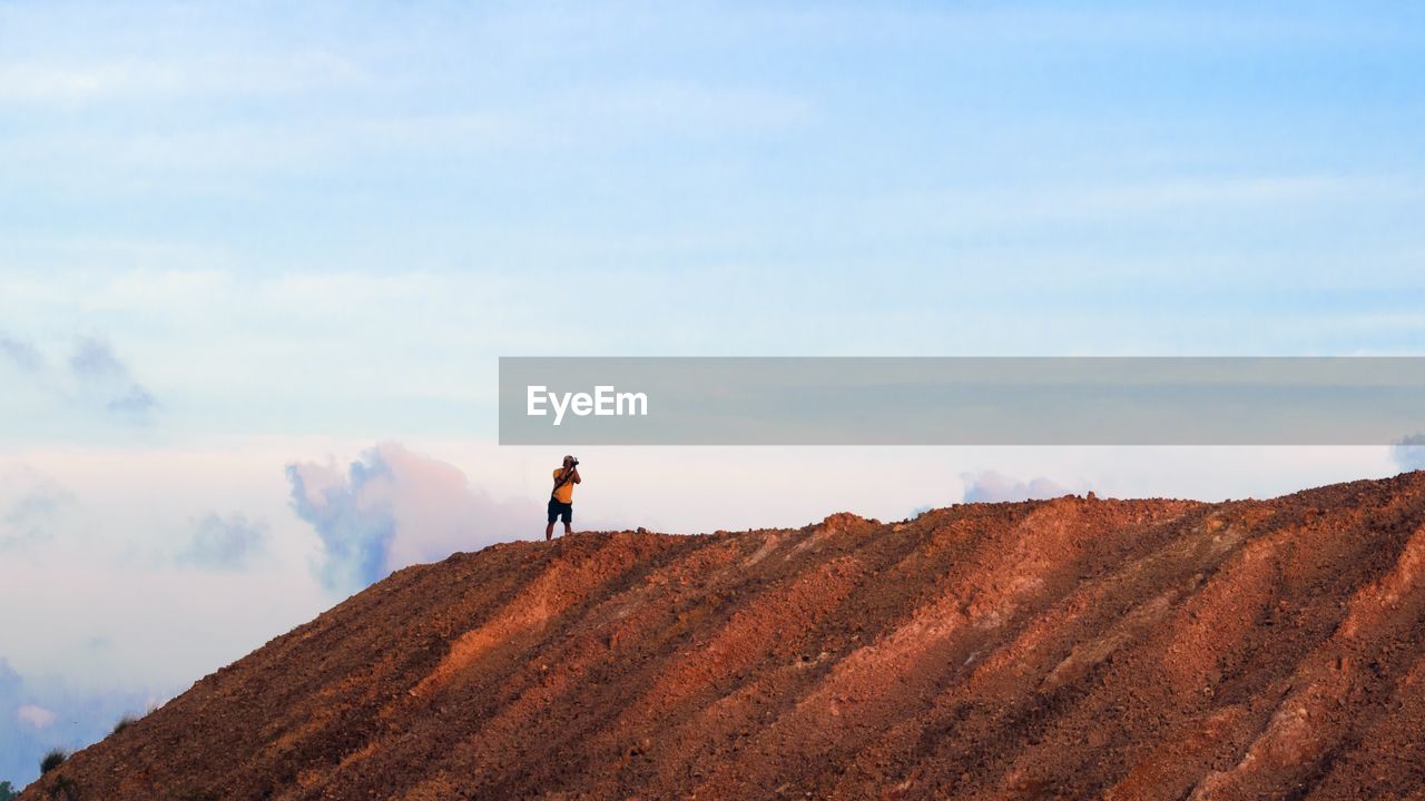 Man standing on desert against sky