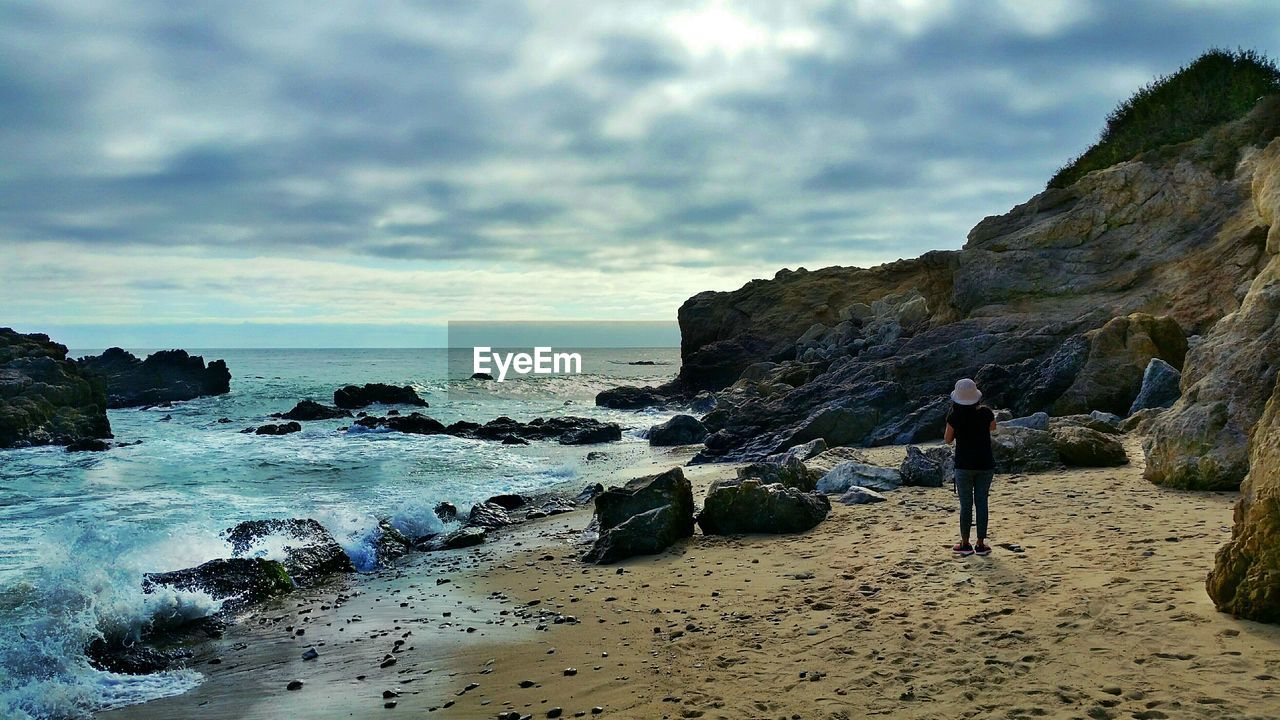 VIEW OF CALM BEACH AGAINST CLOUDS