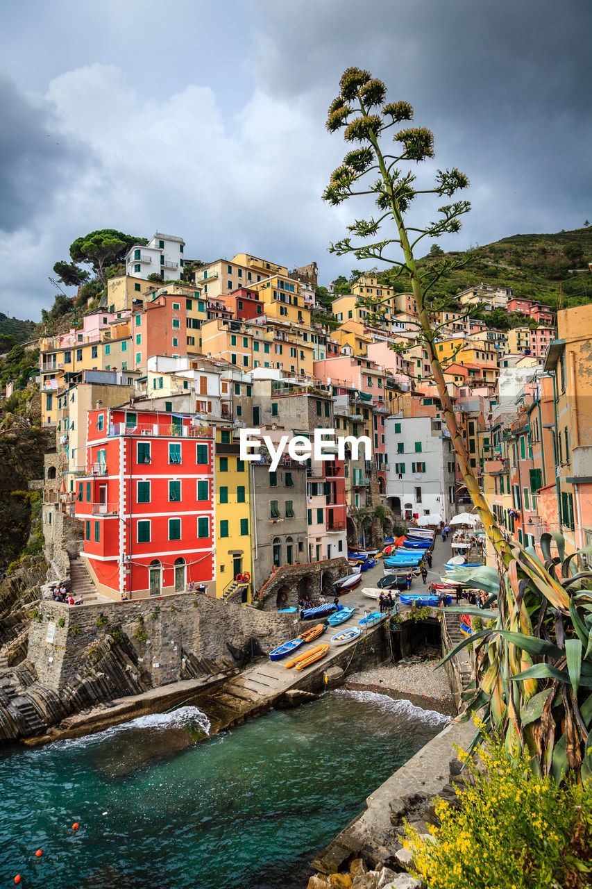 RIVER AMIDST BUILDINGS AGAINST SKY