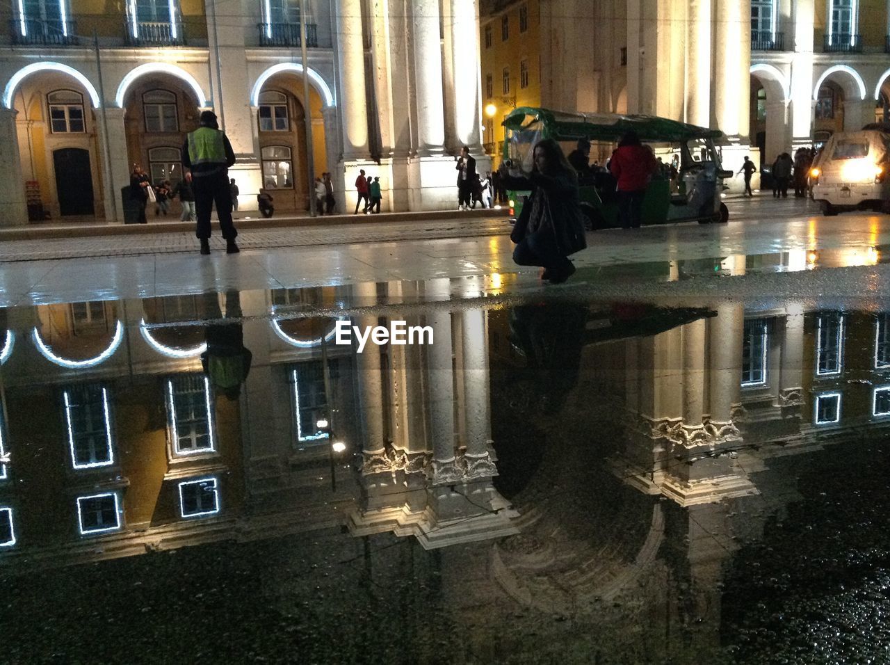 REFLECTION OF ILLUMINATED PUDDLE IN CITY