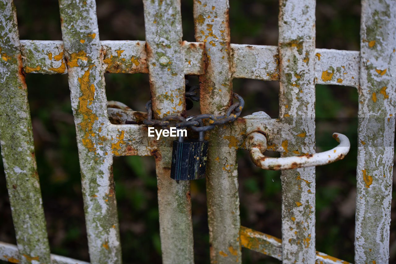 Close-up of rusty padlock on gate