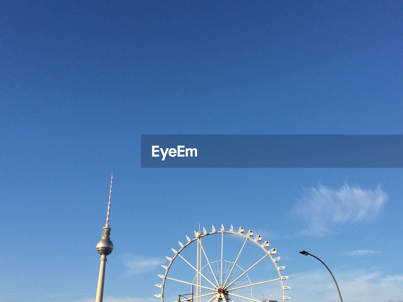 Low angle view of ferris wheel against blue sky