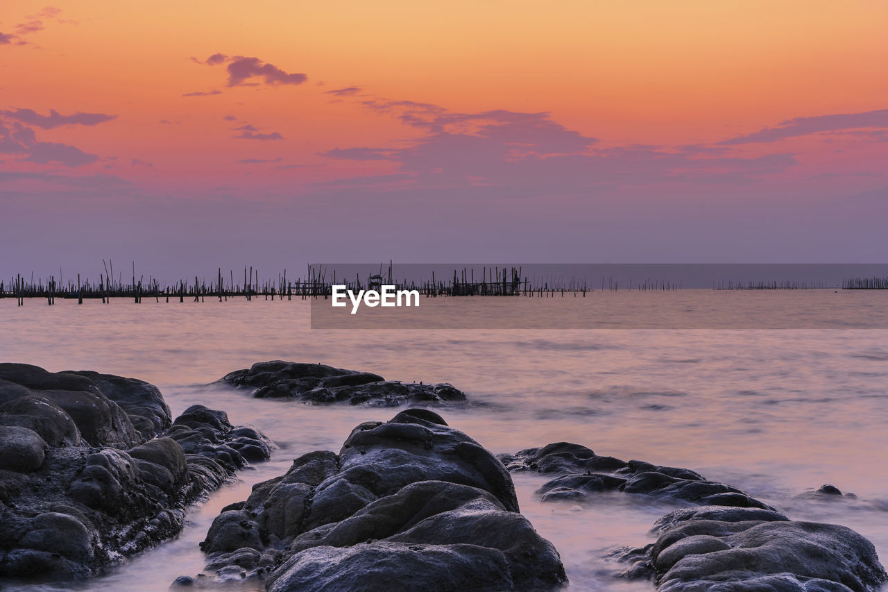 Scenic view of sea against romantic sky at sunset