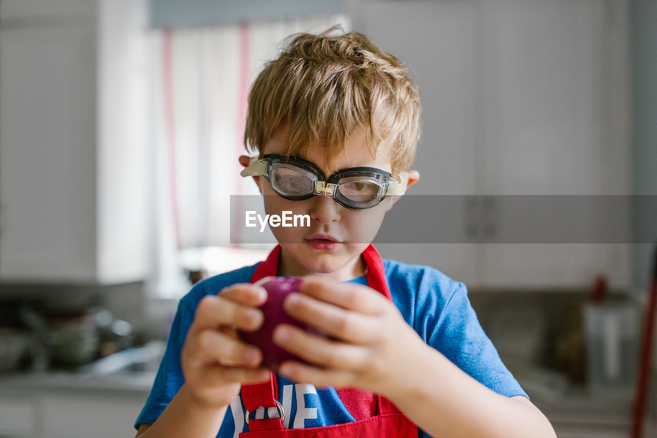 Close-up of boy wearing swimming goggles at home