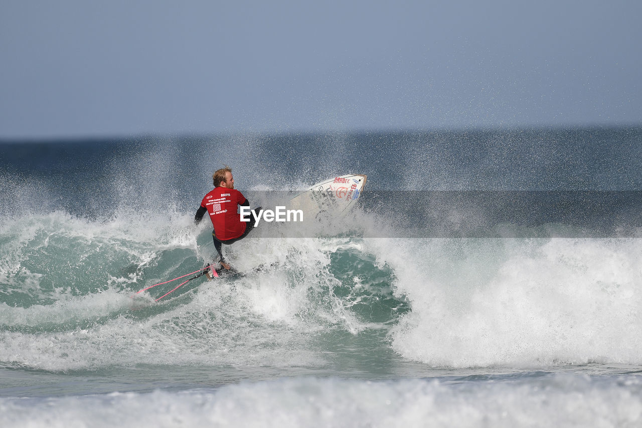 MAN SURFING ON SEA