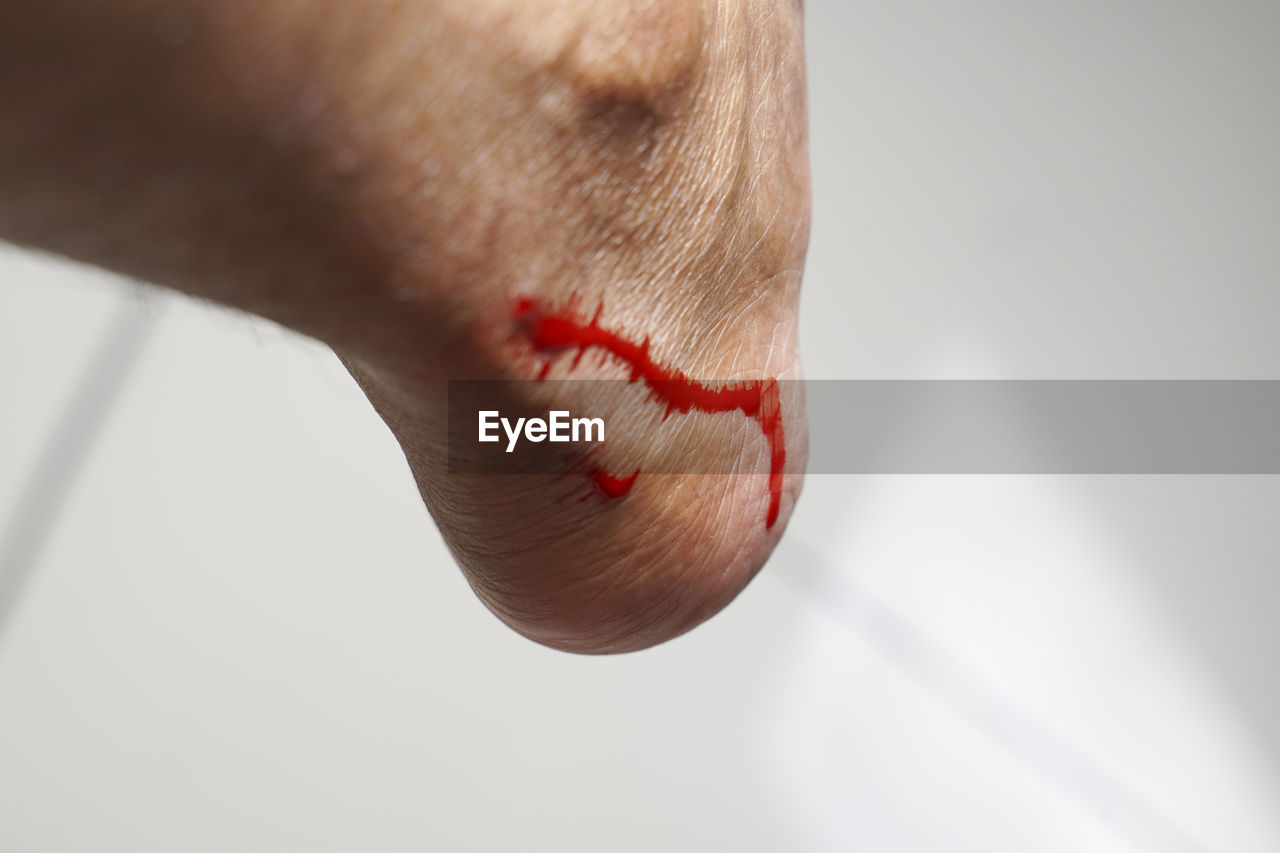 CLOSE-UP OF HUMAN HAND ON RED BACKGROUND