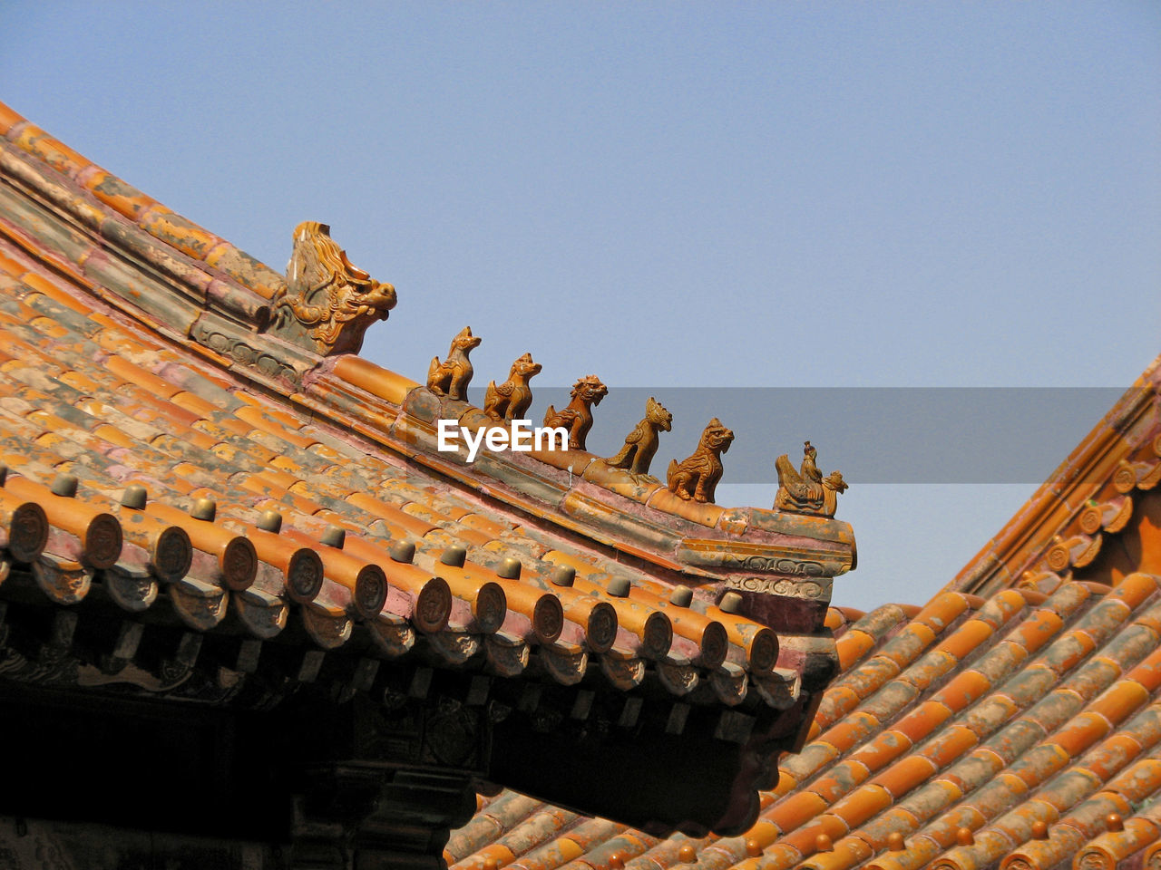 LOW ANGLE VIEW OF SCULPTURES ON ROOF