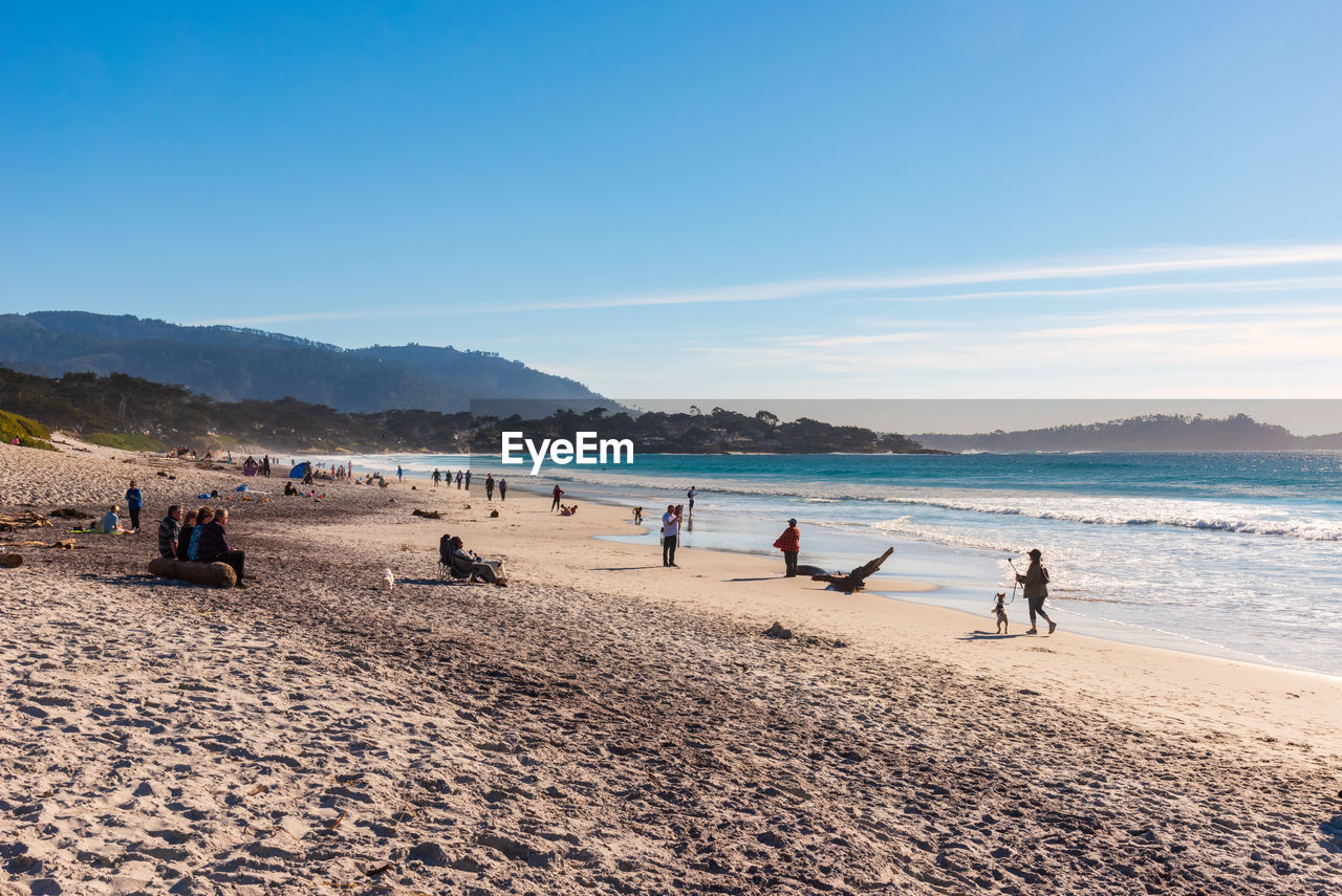 Scenic view of beach with people during sunset