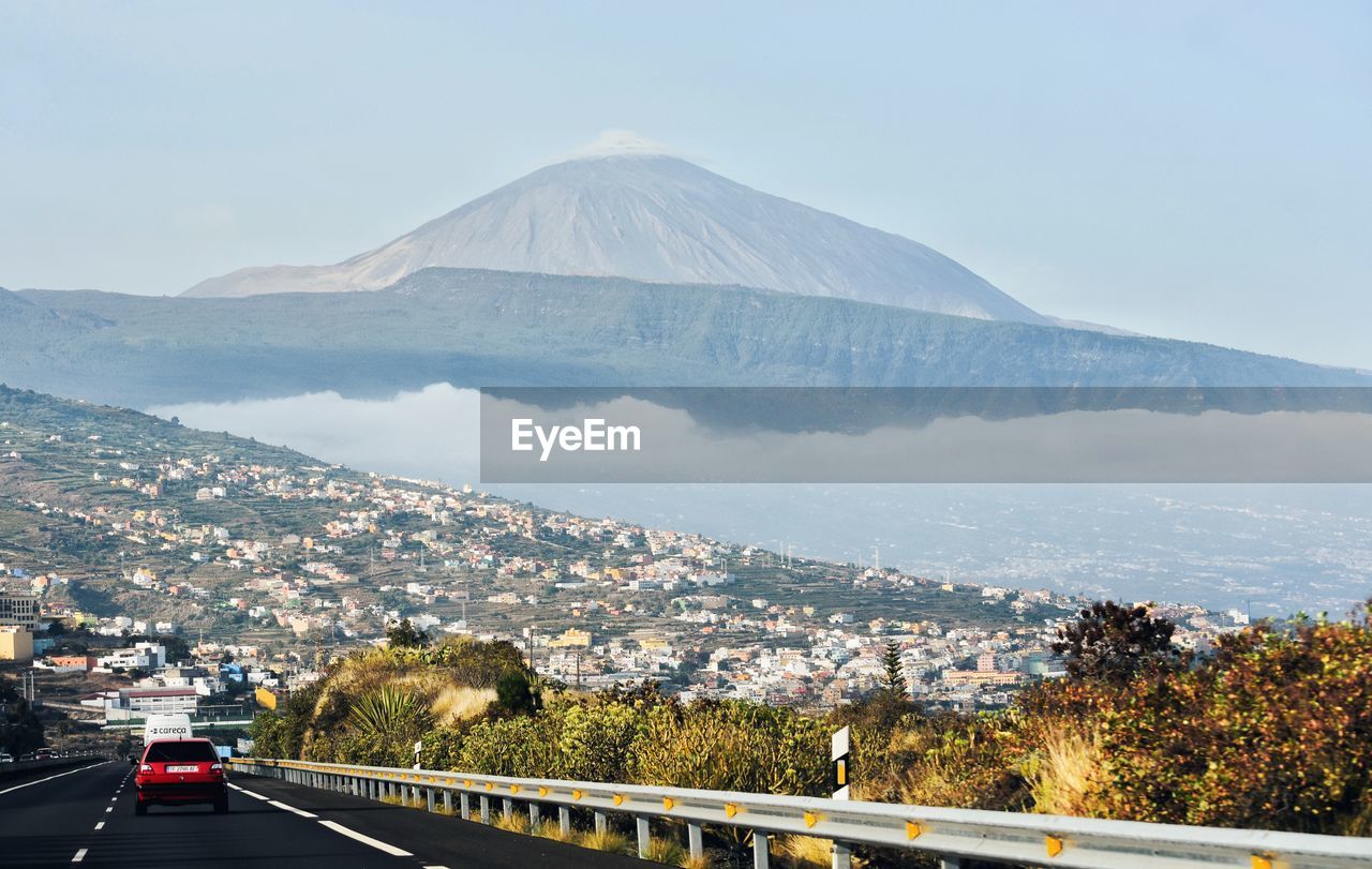 VIEW OF CITY BY MOUNTAIN AGAINST SKY