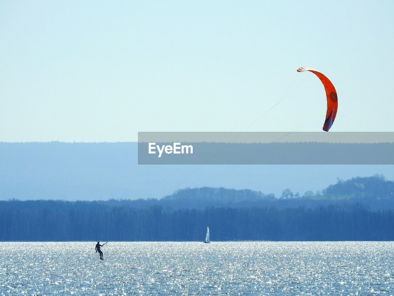 PERSON PARAGLIDING AGAINST SEA