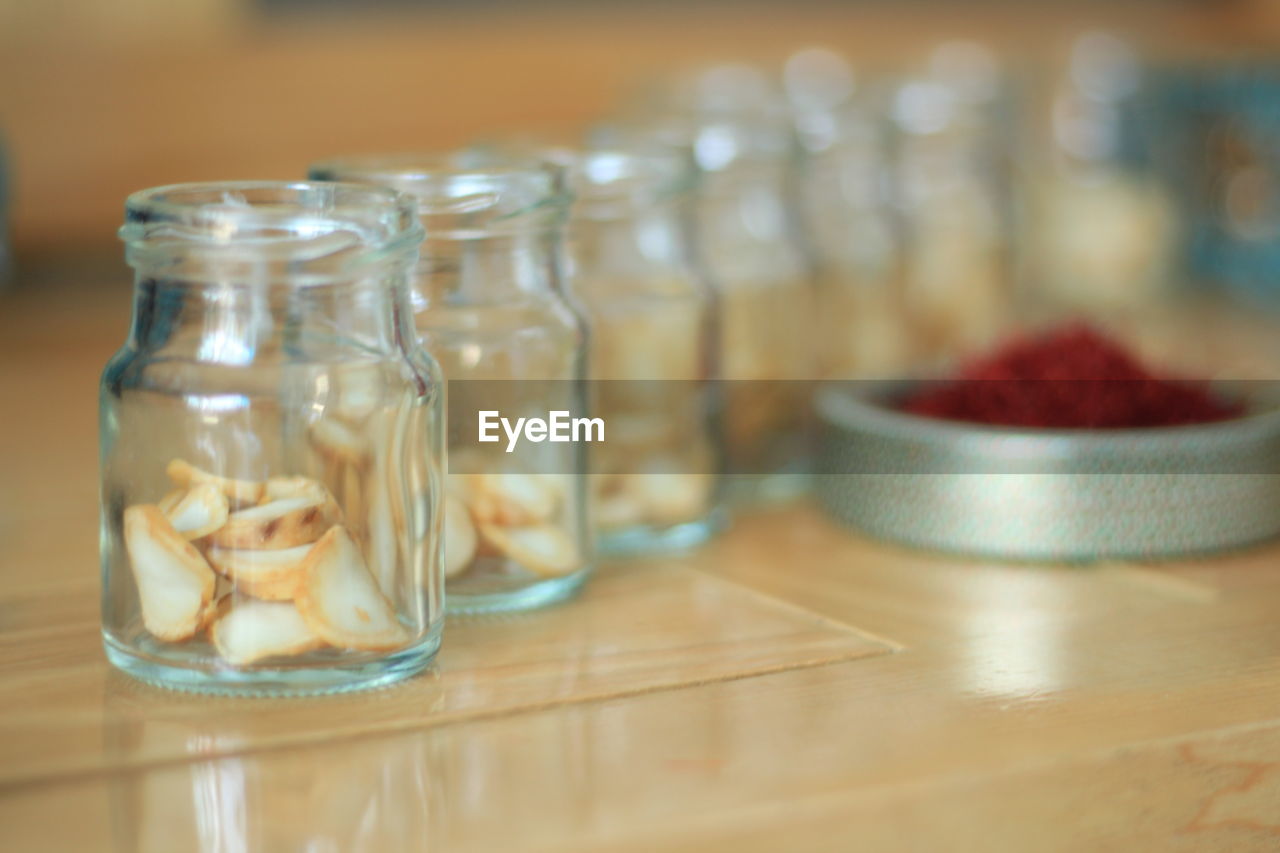 CLOSE-UP OF GLASSES OF JAR ON TABLE