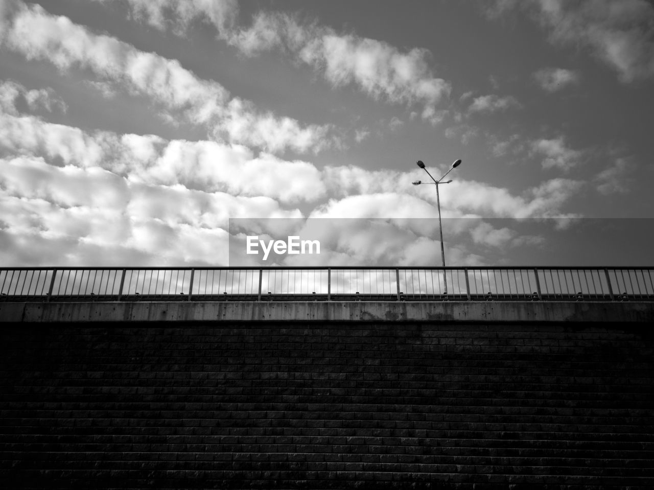 LOW ANGLE VIEW OF BRIDGE AGAINST CLOUDS