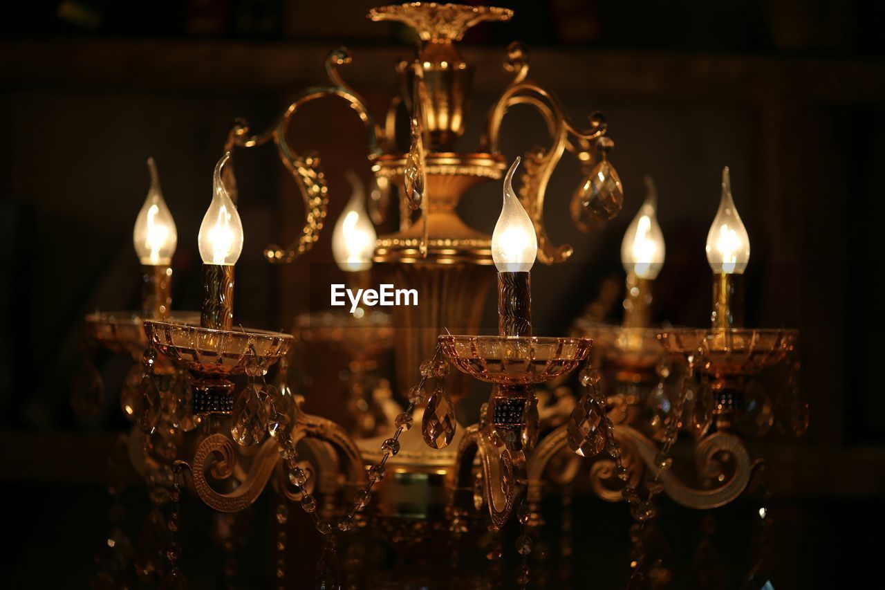 CLOSE-UP OF ILLUMINATED CHANDELIER HANGING IN BAR