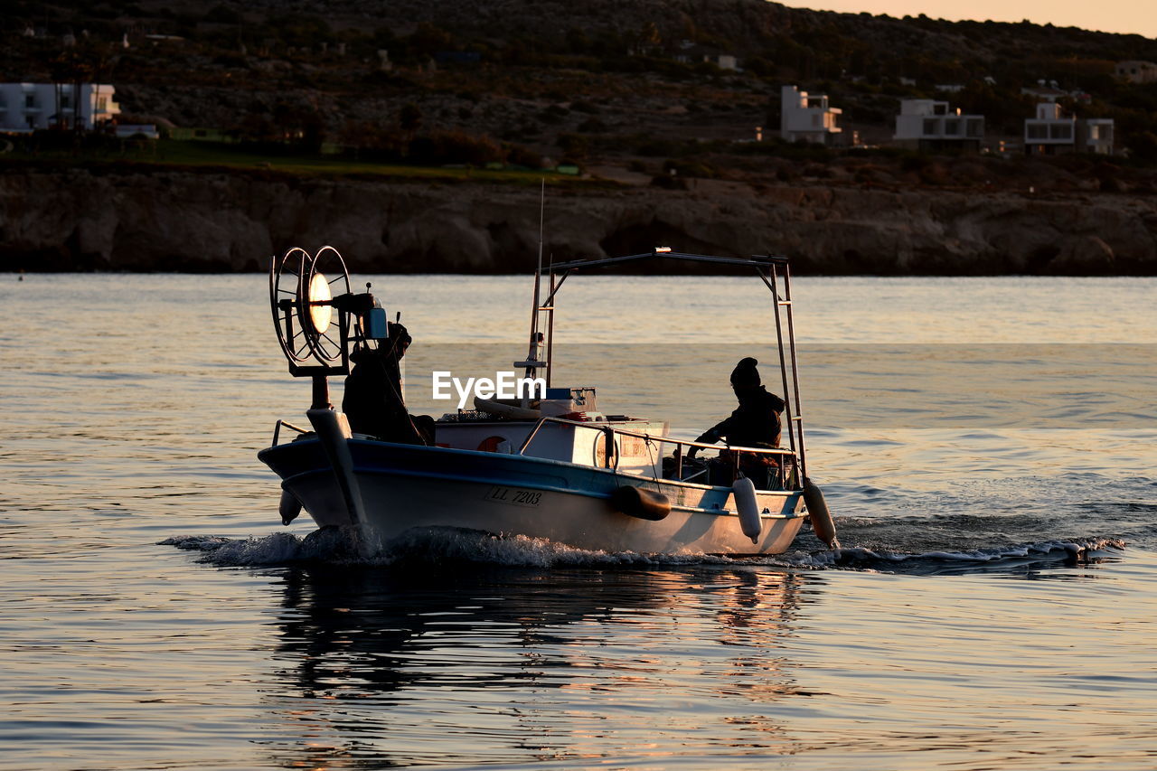 PEOPLE IN BOAT SAILING IN SEA