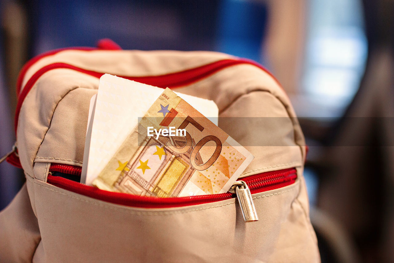 CLOSE-UP OF MAN HOLDING RED BAG