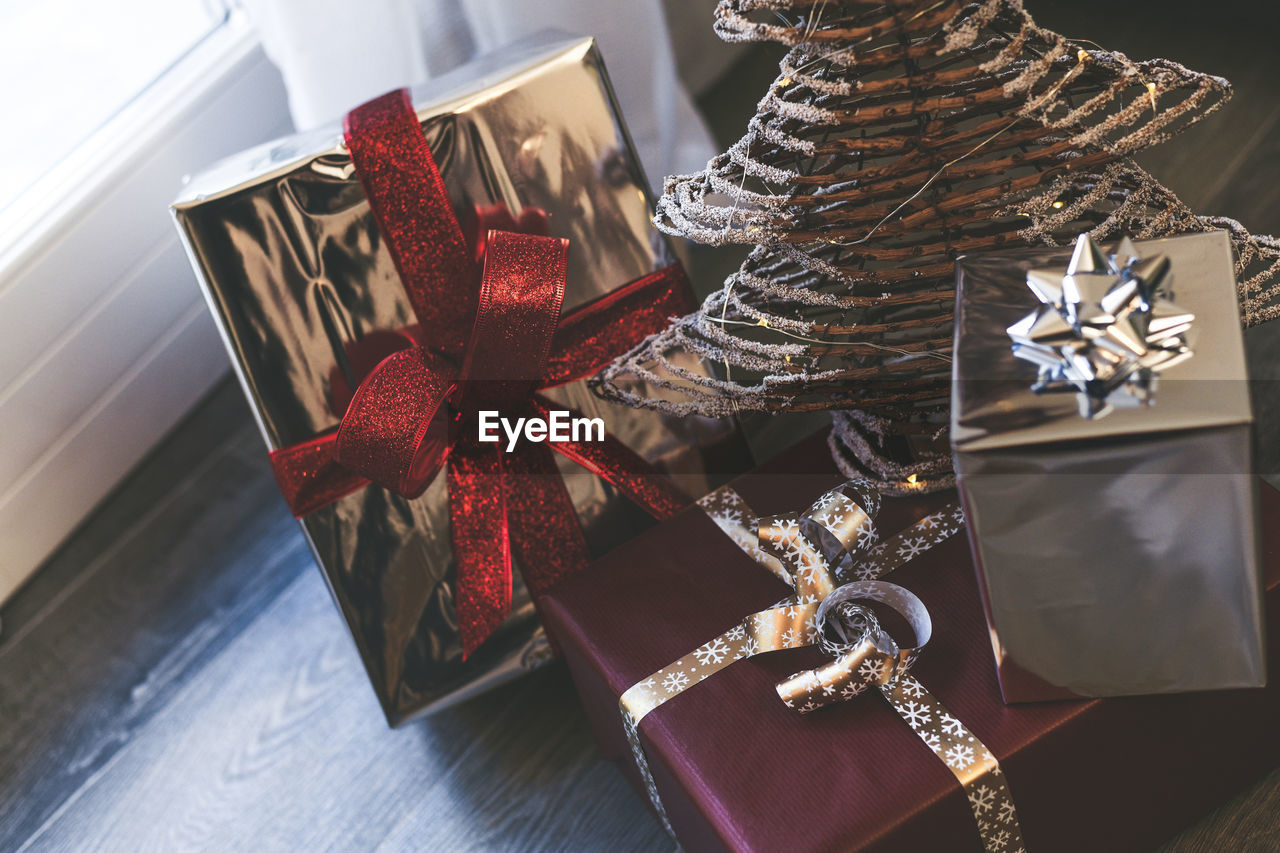 Gift boxes near christmas tree inside home. box with holiday ribbon with bows. festive atmosphere