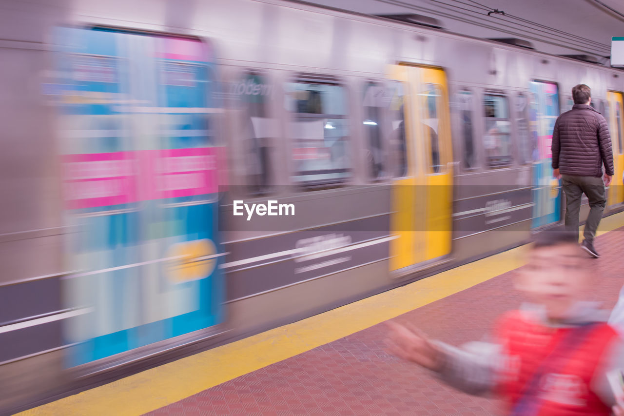 TRAIN MOVING ON RAILROAD STATION PLATFORM