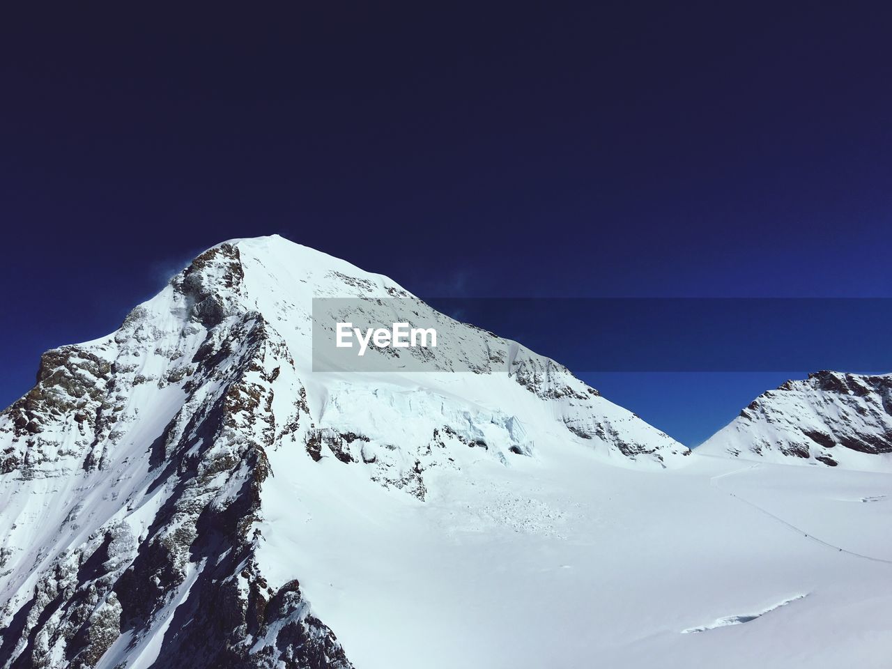 Low angle view of snowcapped mountains against clear sky