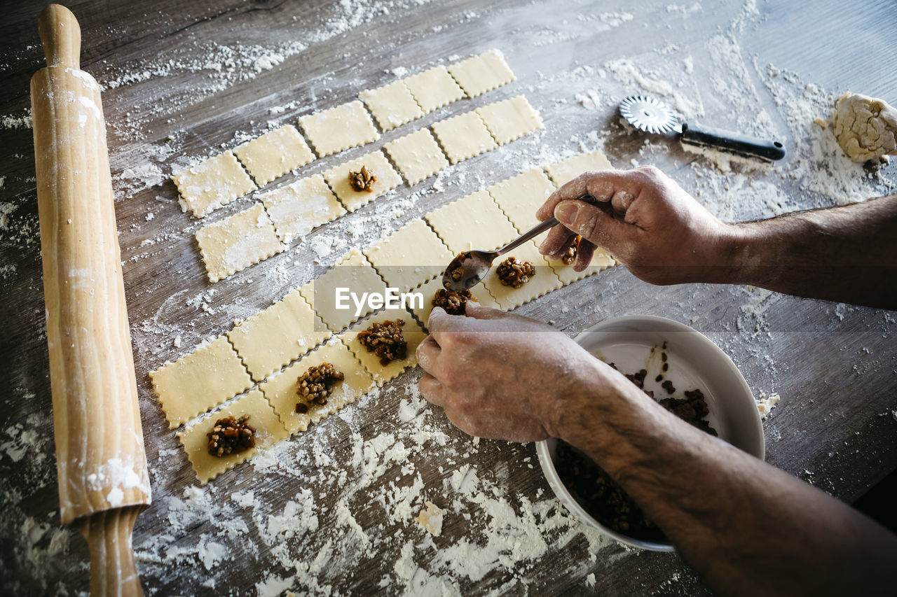 Cropped hands of male chef preparing food on table